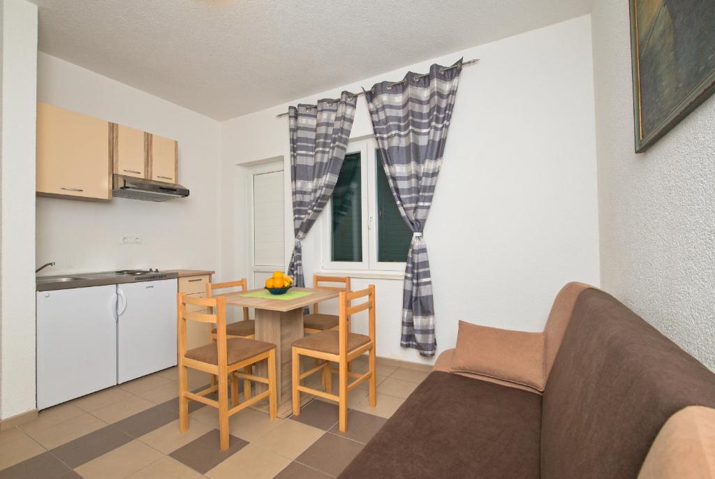 a living room with a table and a kitchen at Apartment Afrika in Makarska