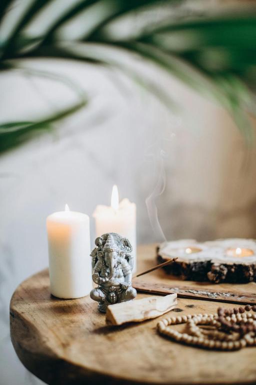 a wooden table with two candles and a necklace at Mantasha Plaza in New Delhi