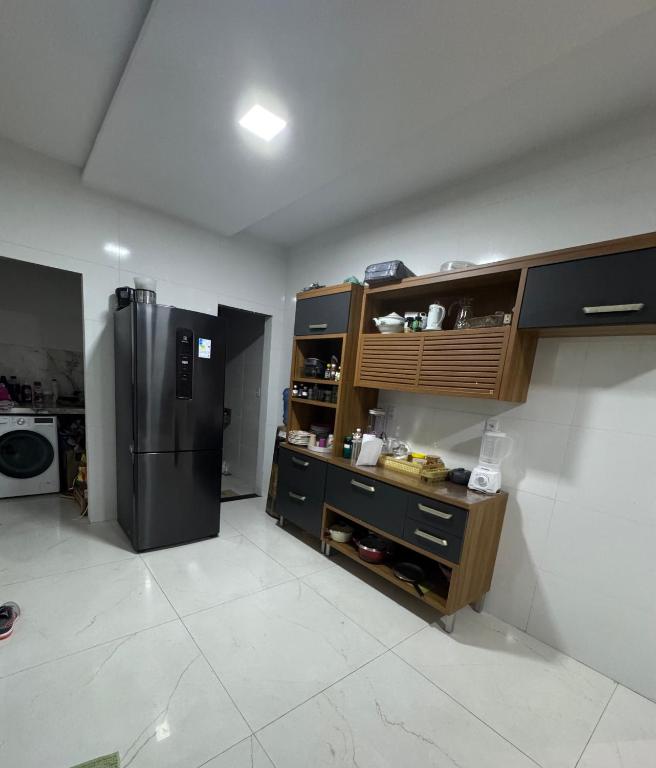 a kitchen with a black refrigerator in a room at Aluguel na cop30 in Ananindeua
