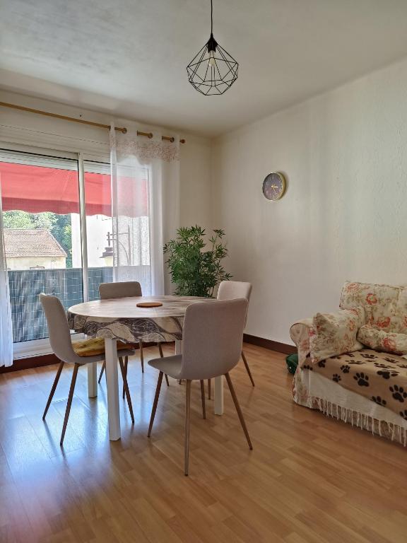 a dining room with a table and chairs and a couch at Appartement 4 pers Balcon Parking gratuit in Amélie-les-Bains-Palalda