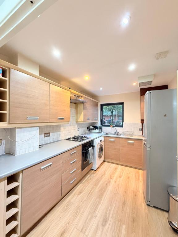 バーミンガムにあるModern 3-Bed Townhouse & Balconyのキッチン(木製キャビネット、ステンレス製の冷蔵庫付)