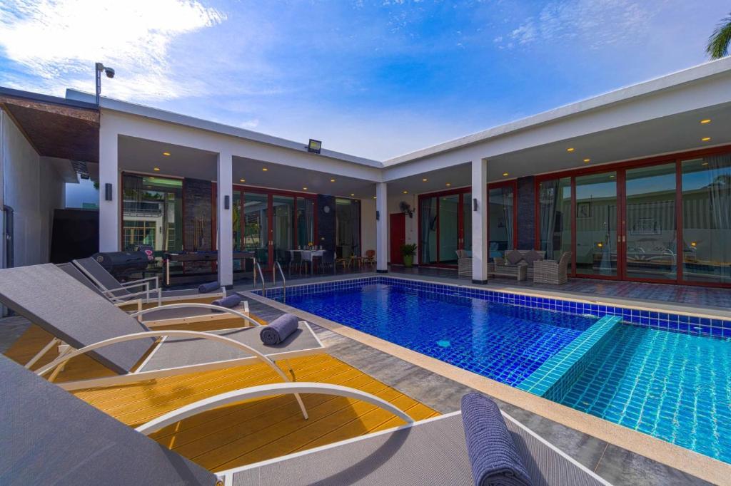 a house with a swimming pool and a house at Beautiful 4-Bedroom Pool Villa - BL9 in Hua Hin