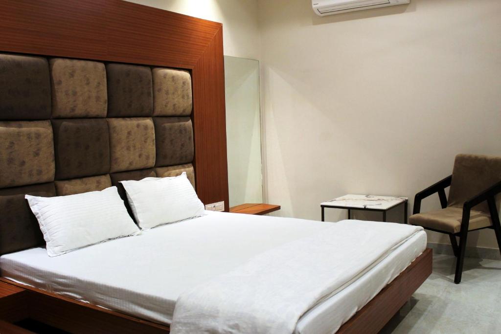 Un dormitorio con una cama grande y una silla. en Devi villa, en Bikaner