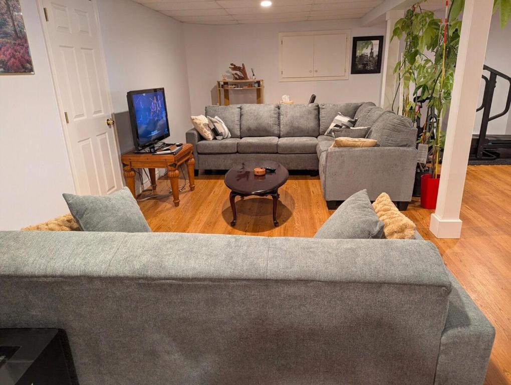 Una sala de estar con dos sofás y un televisor. en The Convenient Suite, en Charlottetown