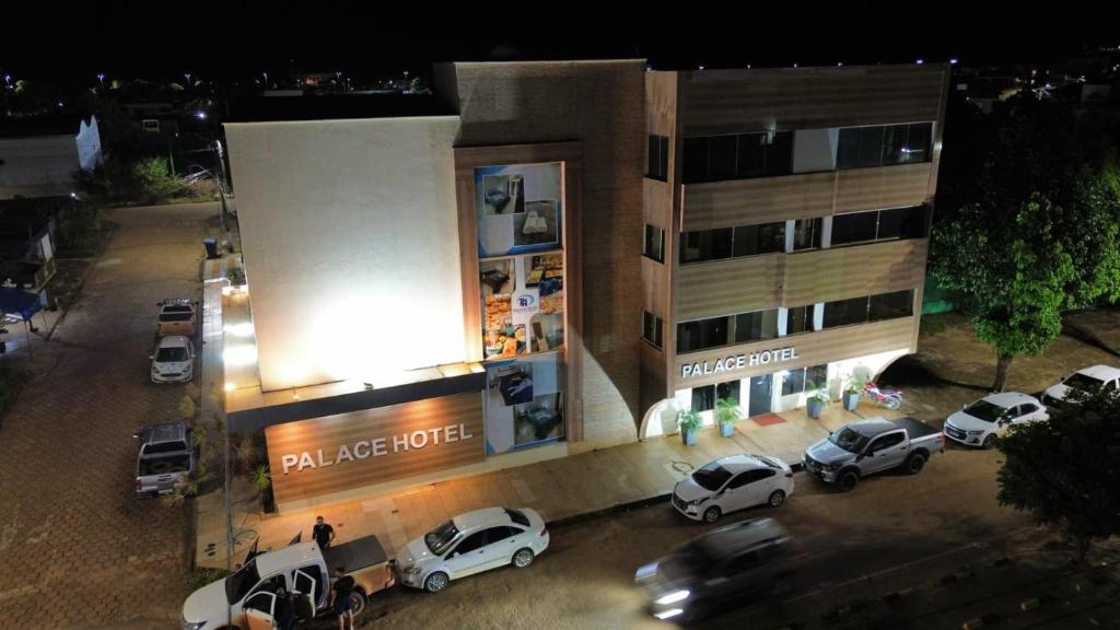 a parking lot in front of a building with parked cars at Palace Hotel in Altamira