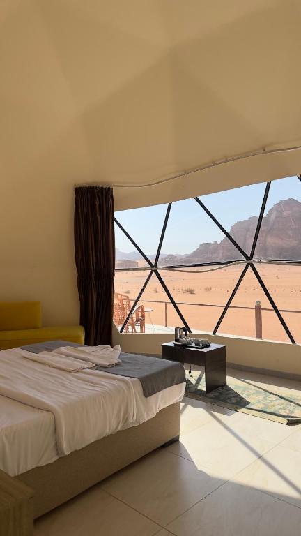 a bedroom with a bed and a view of the desert at Milano Rum Luxury Camp in Wadi Rum