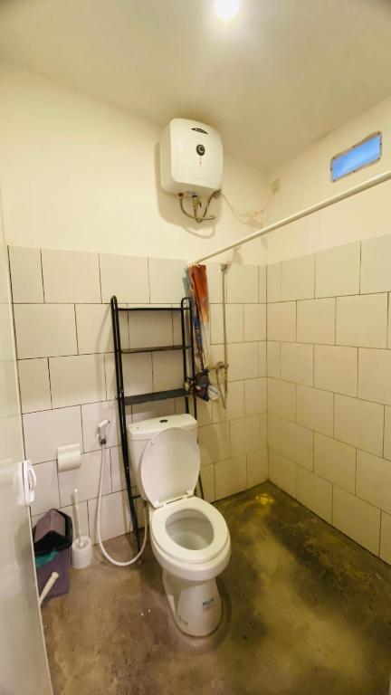 a bathroom with a white toilet in a room at Wong village 106 in Tumbak Bayuh