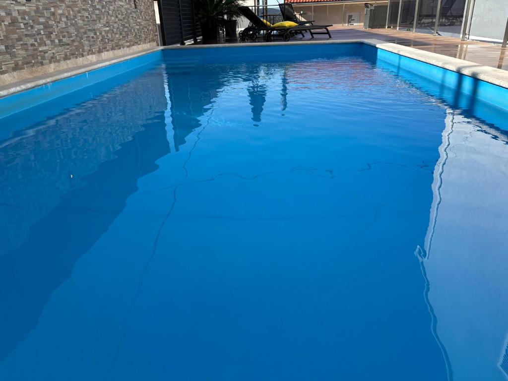 a pool of blue water in a swimming pool at POOL me up! in Šibenik