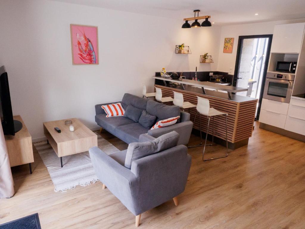 a living room with a couch and a table at Ker Mamie-Paule charmante, petite maison, située entre Saint-Malo et le Mont-Saint-Michel in Le Vivier-sur-Mer