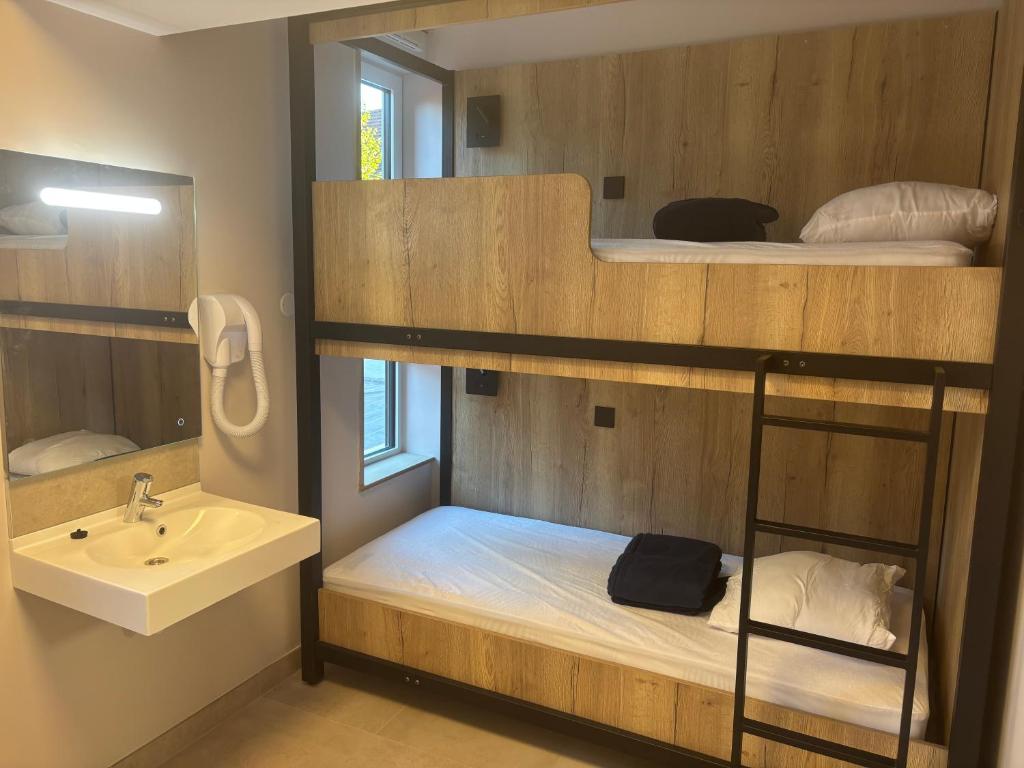 Auberge de Jeunesse Les Francas du Pas-de-Calais - ARRAS في Saint-Laurent-Blangy: حمام مع سرير بطابقين مع حوض ومرآة