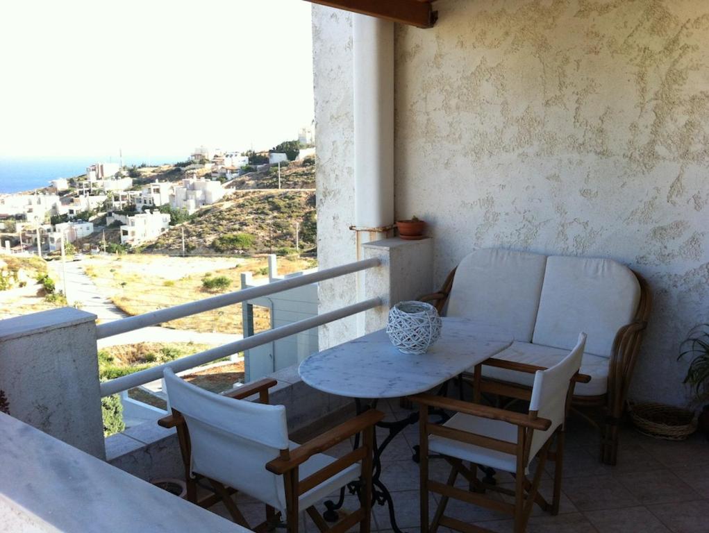 a table and chairs on a balcony with a view at Family Apartment Ammoudi in Agia Pelagia