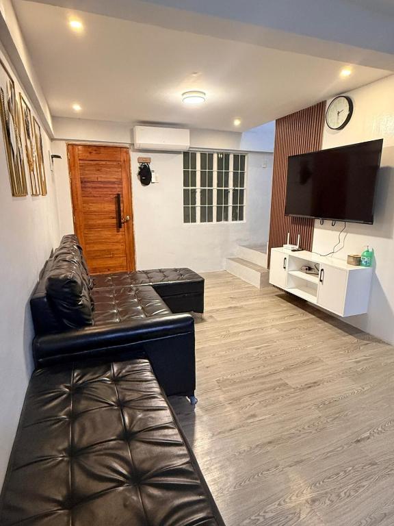a living room with a couch and a flat screen tv at Casa Tres - home in San Mateo 