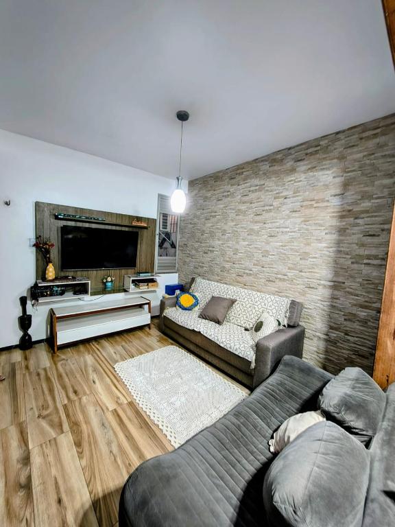 a living room with a couch and a brick wall at Casa do Marco&Leoni in Belém