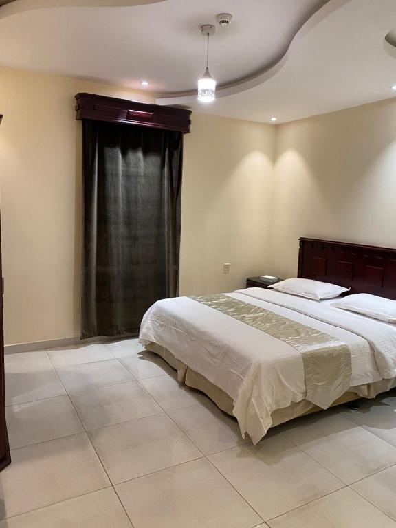 una camera da letto con un letto grande e una finestra di المساكن الذهبيه للشقق المخدومه a Khamis Mushayt