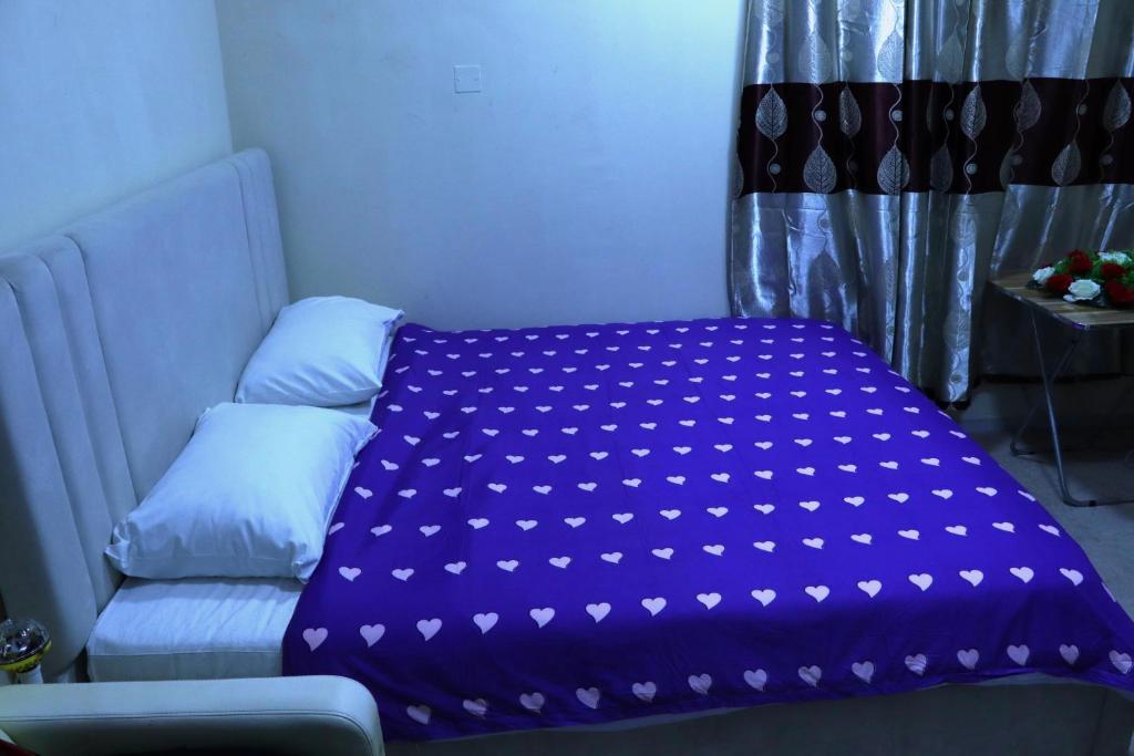 Una cama con una manta morada encima. en Dreams Studio Apartments - Deira, en Dubái