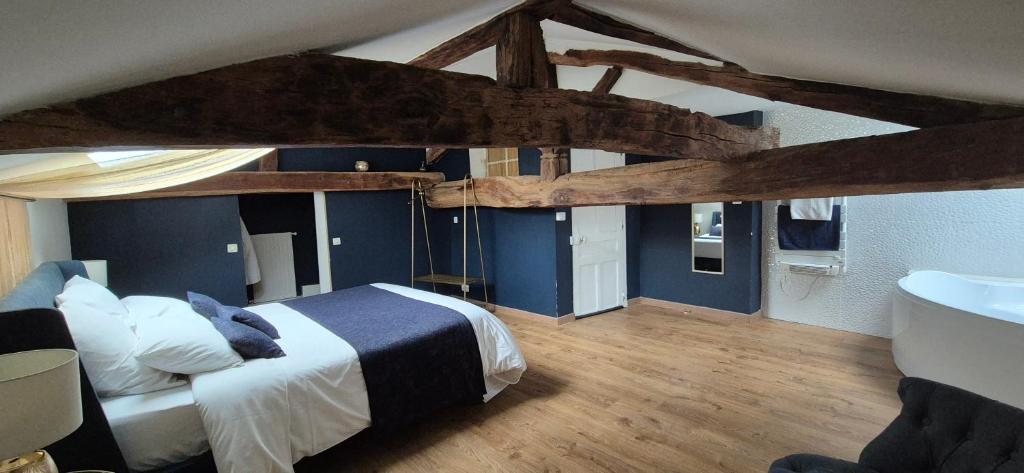 a bedroom with a large bed and a bathroom at Domaine de la Fée-Licité in Jullié