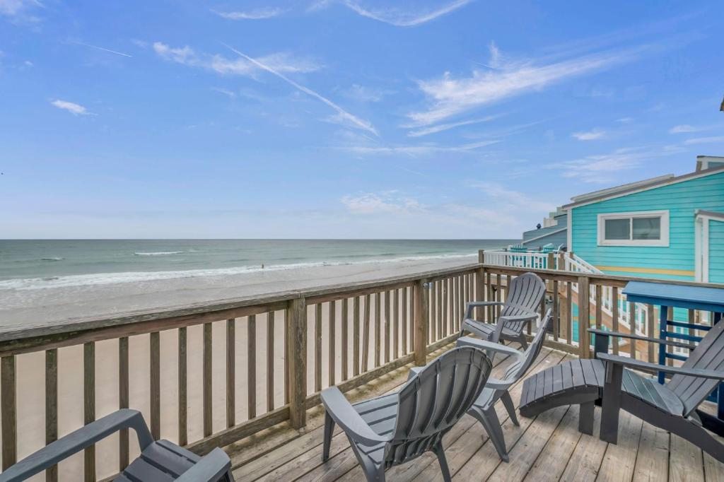 a deck with two chairs and a house and the beach at Tipsy Traveler in North Topsail Beach