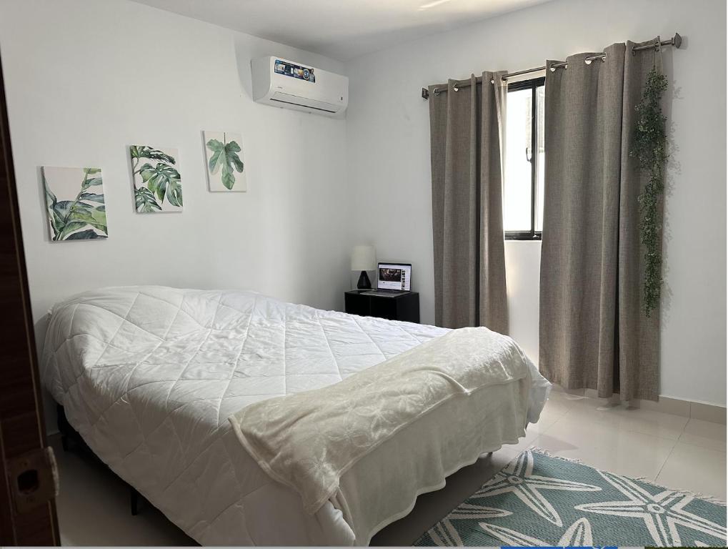 une chambre blanche avec un lit et une fenêtre dans l'établissement Santo Domingo Tropical Peaceful Escape Ocean Front Near Boca Chica Airport, à La Golondrina