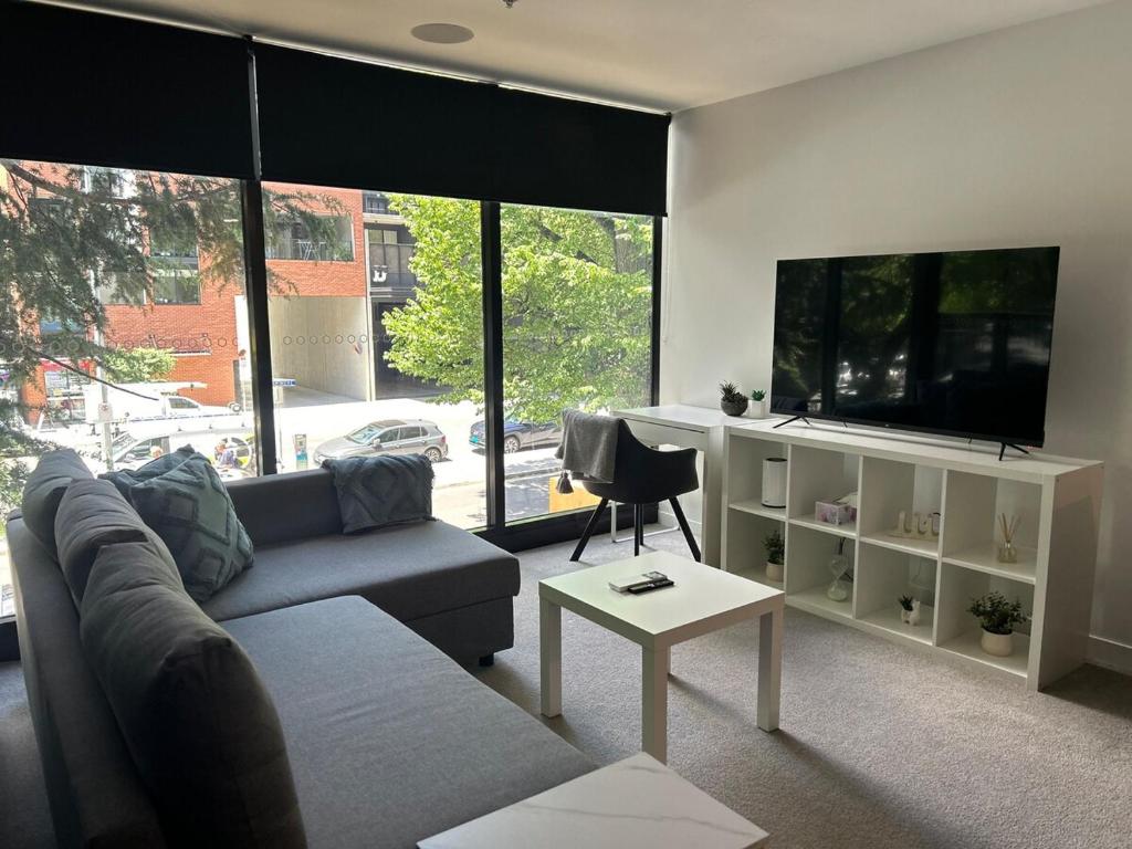 un salon avec un canapé et une télévision à écran plat dans l'établissement Plush 221 Midnight Braddon 2bedroom 2bathroom Free parking Free wifi, à Braddon