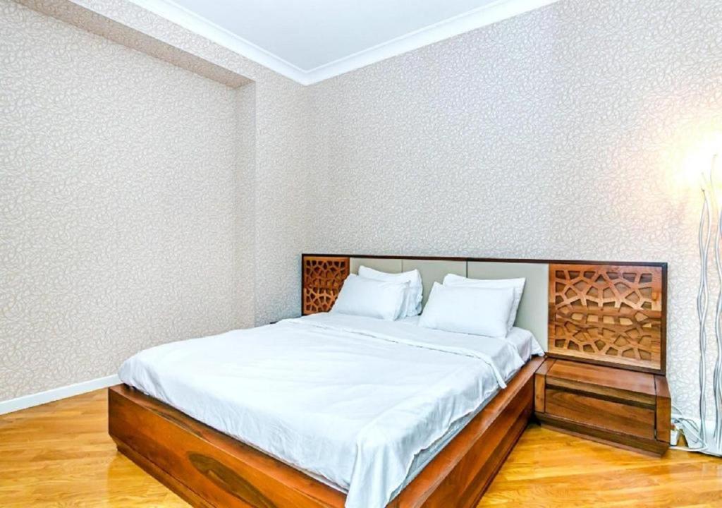 une chambre avec un grand lit avec des draps blancs dans l'établissement Serenity Lodge Residencia, à Islamabad