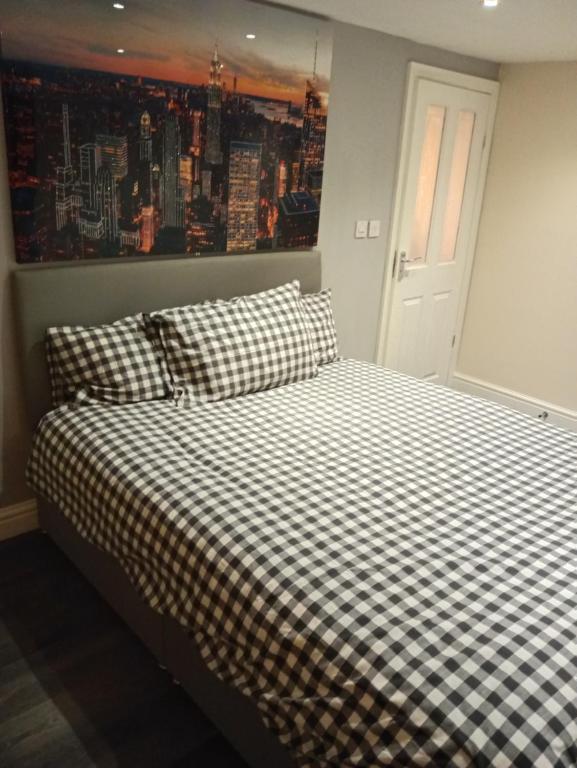 a bedroom with a bed with checkered sheets and a window at Lower Cheltenham Place in Bristol