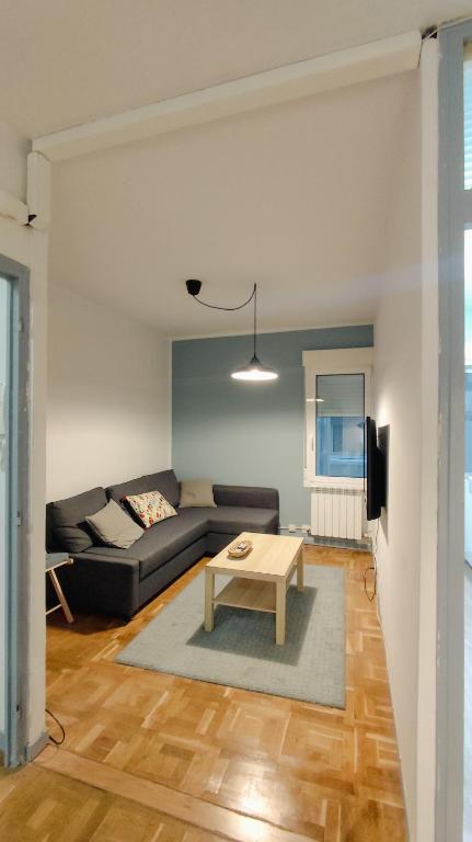 una sala de estar con un sofá y una mesa en Dormitalería, en Pamplona