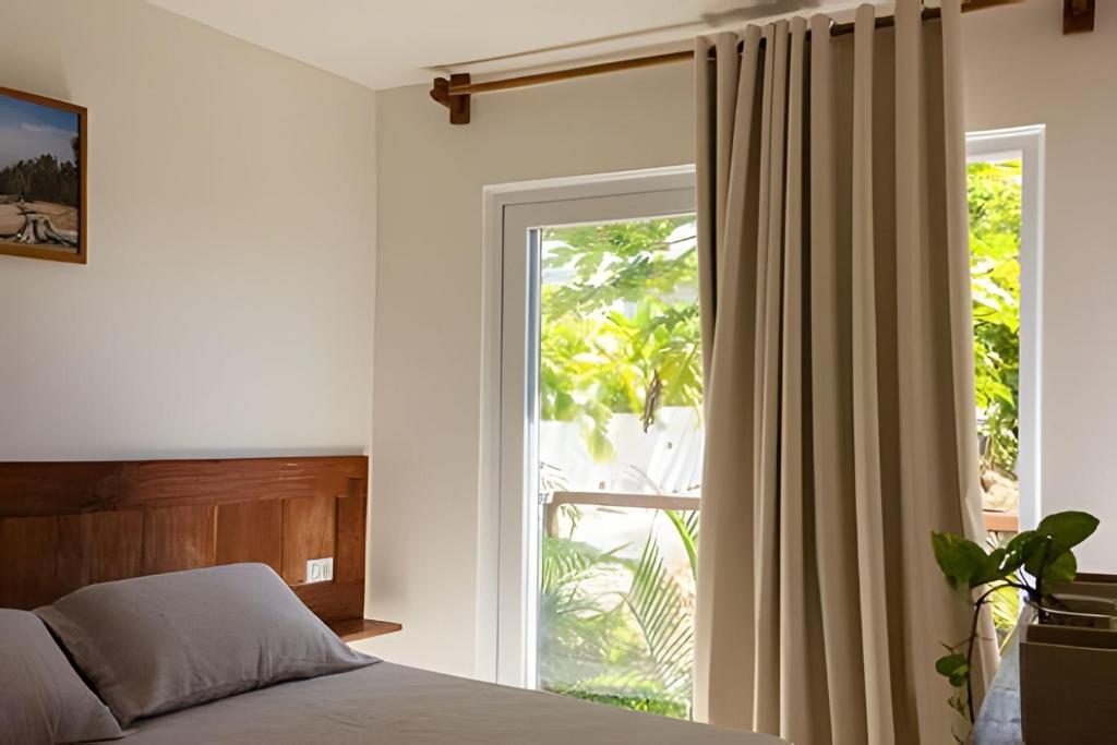 モロ・デ・サンパウロにあるMAR DÁ LIBERDADE com Postal do Farolのベッドと大きな窓のある寝室