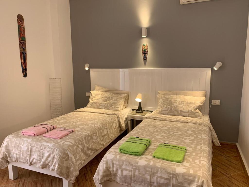two beds in a room with green towels on them at Luxury Apartment Ritz Carlton in Sharm El Sheikh