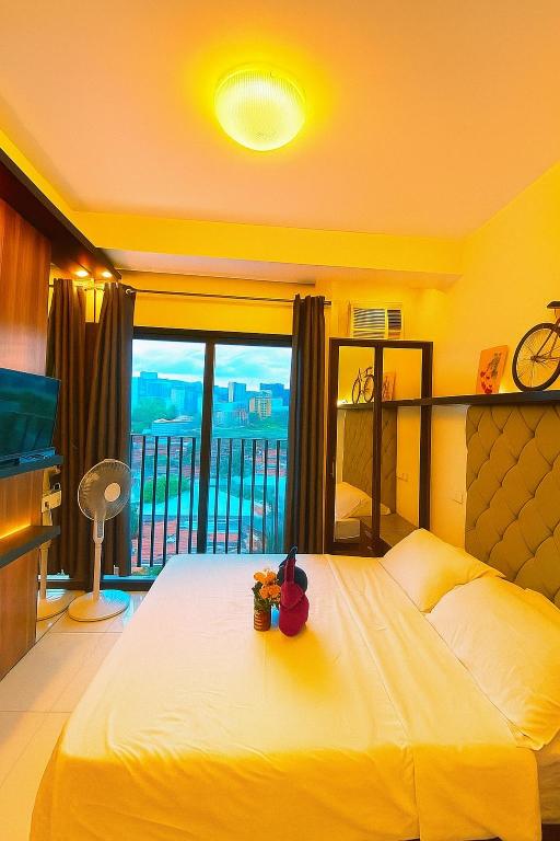 a bedroom with a large bed and a balcony at 1bedroom Lot8 condo in Cebu City