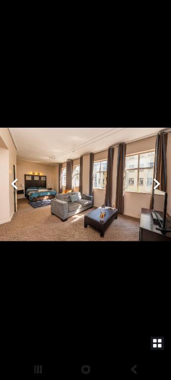 a living room with a couch and a room with a fireplace at Native Suites 411 in Johannesburg