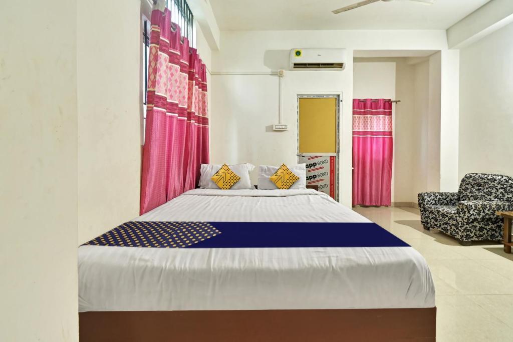 a bedroom with a large bed and a chair at Hotel O Homely Residency in Guwahati