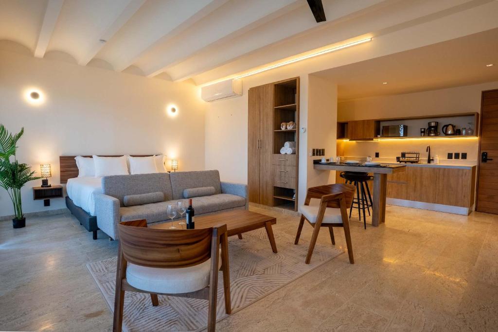 a hotel room with a bed and a living room at Nomad Studio Fast WiFi and Rooftop Pool in Cancún