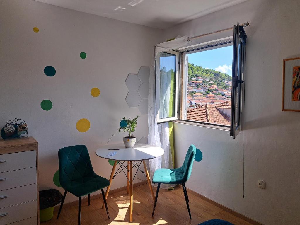 a room with a table and two chairs and a window at Smještaj Latica in Vela Luka