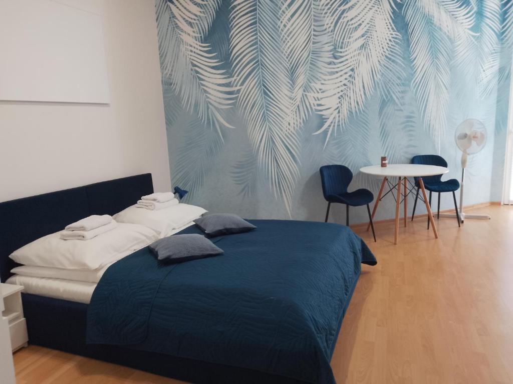 a bedroom with a bed and a table and chairs at Apartament Niebieski Lwowska 56 in Nowy Sącz