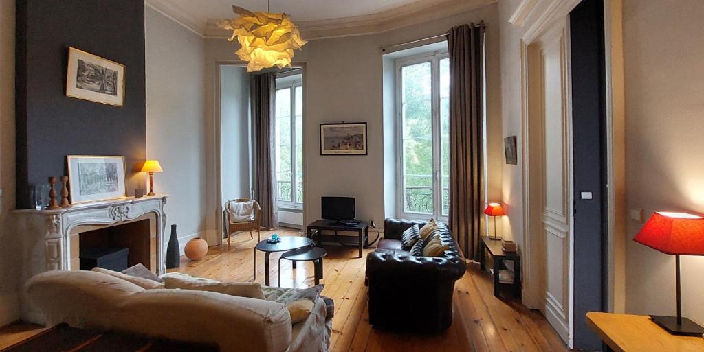 een woonkamer met een bank en een open haard bij Burdigala Homes - Appart Clemenceau in Bordeaux