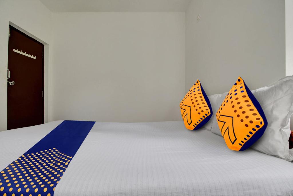 a bed with orange and blue pillows on it at Hotel O U & I LIVINGS in Goa
