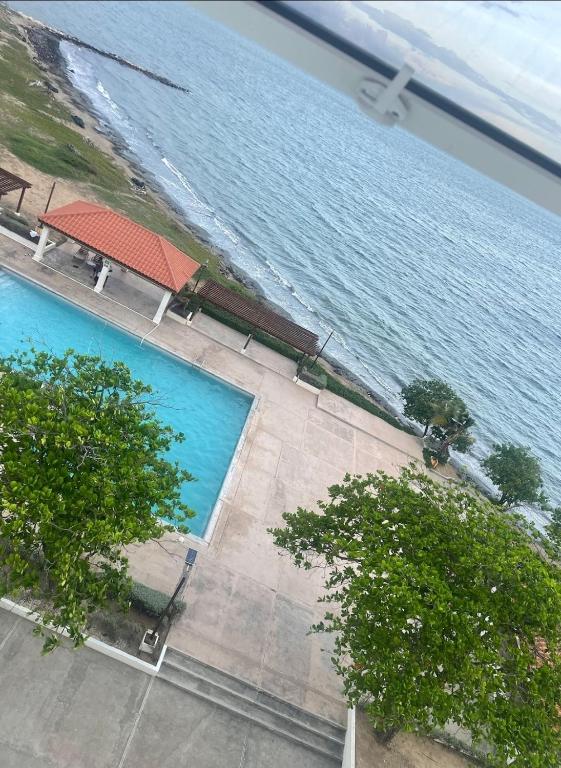 einen Blick über einen großen Pool neben dem Wasser in der Unterkunft Spacious two bedrooms with sea and city view in Portmore