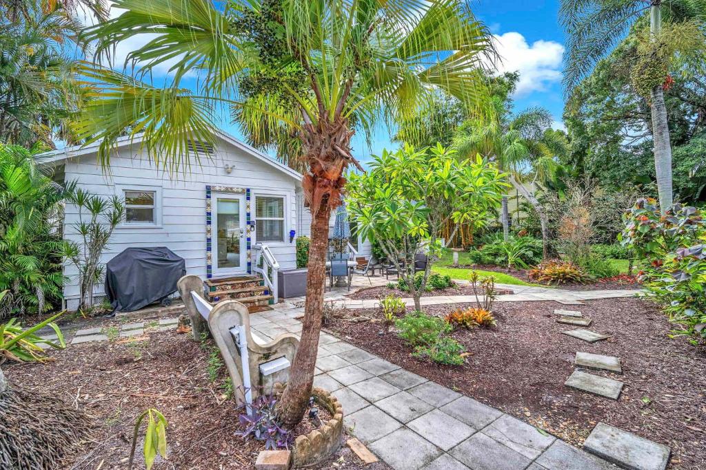 a house with a palm tree and a bench at Bromeliad Bungalow - Downtown Cottage in Fort Lauderdale