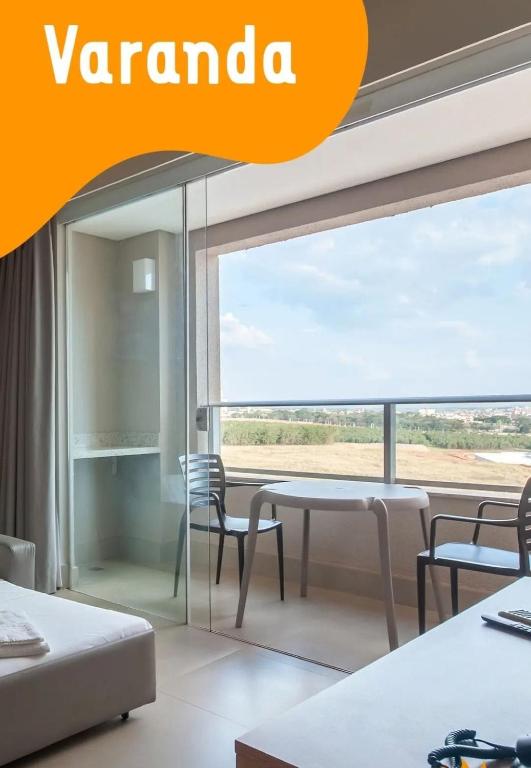 ein Raum mit einem Tisch und Stühlen und einem Fenster in der Unterkunft Solar das Aguas Resort in Olímpia