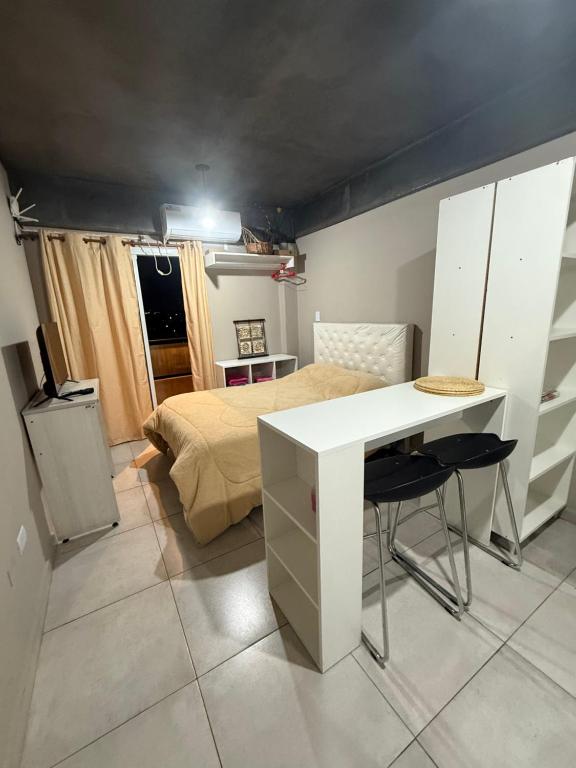une chambre avec un lit, une table et un bureau dans l'établissement CHINO I, à San Miguel de Tucumán