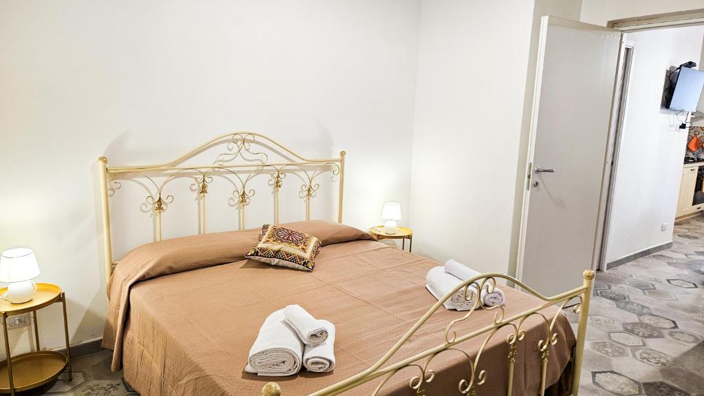 a bedroom with a bed with two pairs of shoes on it at Jasmine House Ustica heart in Ustica