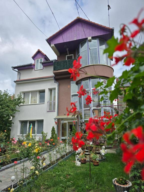 a large house with flowers in the yard at Rodica Apartment in Sibiu