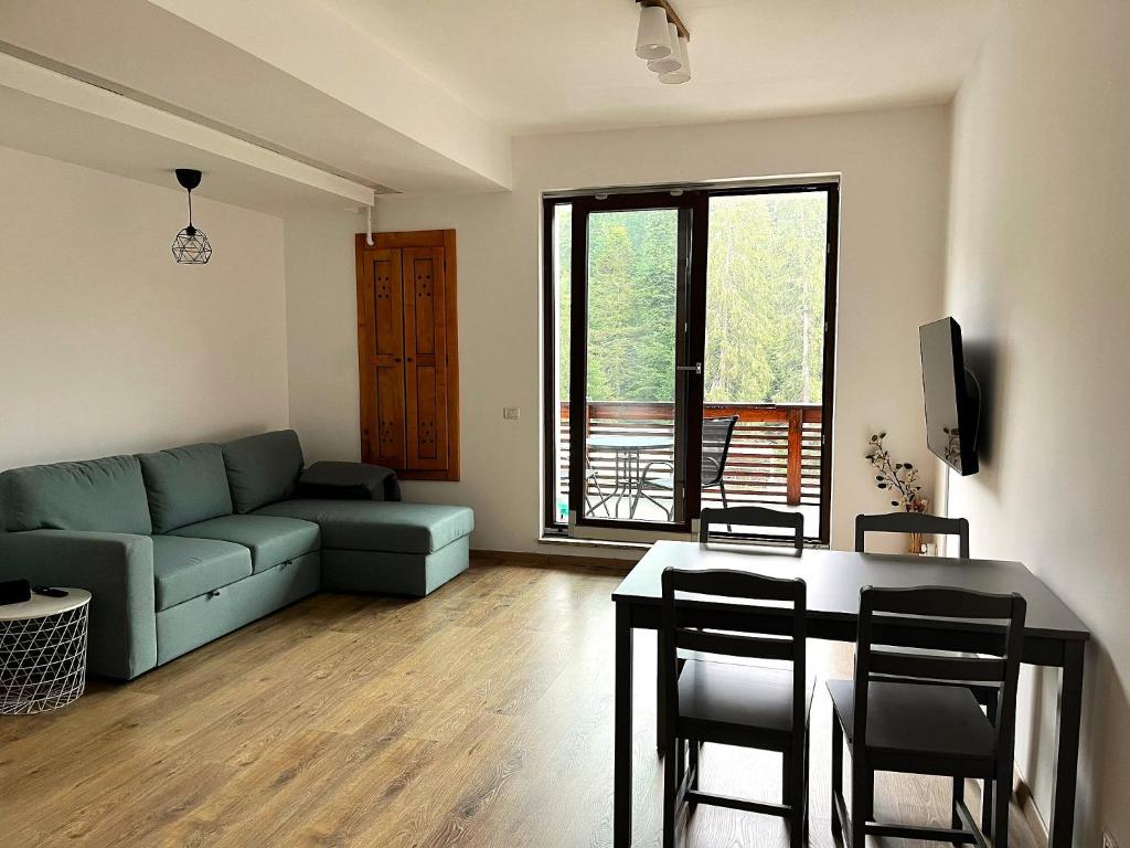 a living room with a couch and a table at Panorama Pine Retreat - Spacious 2-Bedroom Flat in Predeal
