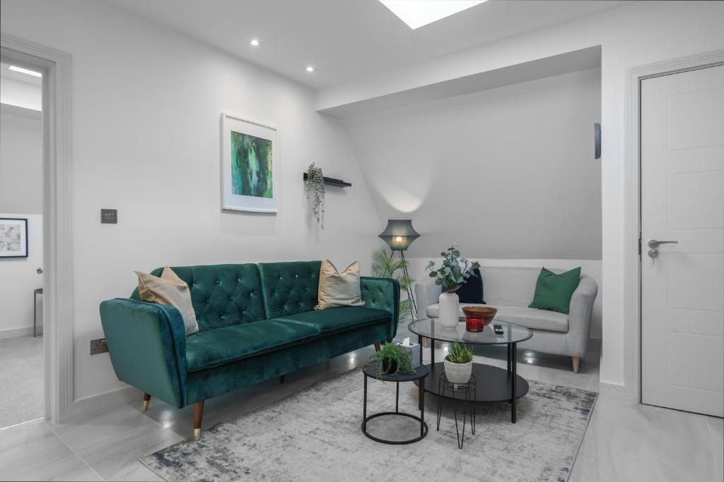 a living room with a green couch and a table at Contemporary Didcot Apartments for Work & Leisure in Didcot