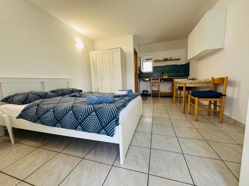 a bedroom with a bed and a kitchen with a table at Bright Side Studios in Ljubljana