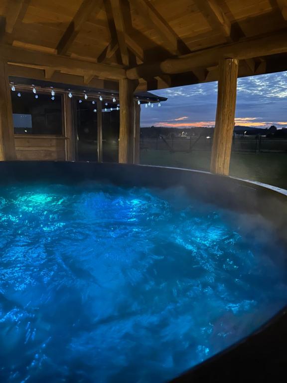 a hot tub with blue water in a house at Domek pod lasem in Bolmin
