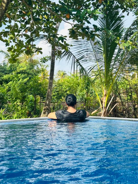 a man is sitting in a swimming pool at Sekkugala Villa in Koggala