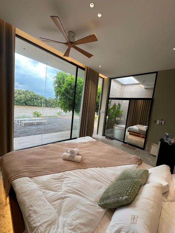 a bedroom with a large bed with a large window at Phú Xuân Homestay - Gần Dốc Hoàng Hôn, Phòng Rộng View Sông in Phan Thiet