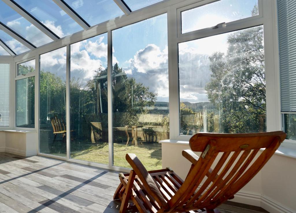 a rocking chair sitting in front of a large window at The Peak View - Holmfirth in Cartworth