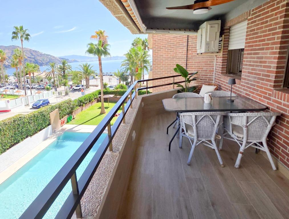 アルムニェーカルにあるVelilla Seaview with Pool and Parkingのバルコニー(テーブル、スイミングプール付)